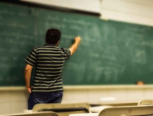 man in black and white polo shirt beside writing board